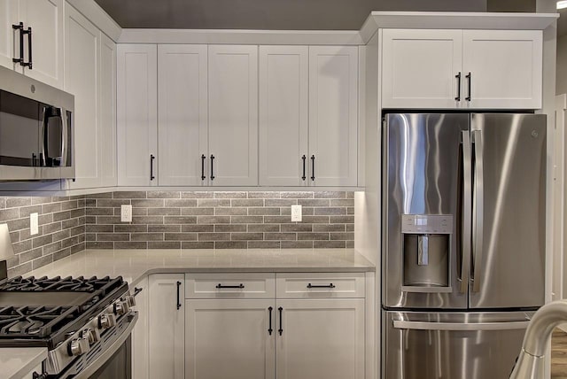 178 Meadow Vista Loop Unit A, Kalispell, MT 59901 - kitchen featuring appliances with stainless steel finishes, white cabinetry, tasteful backsplash, and light stone counters