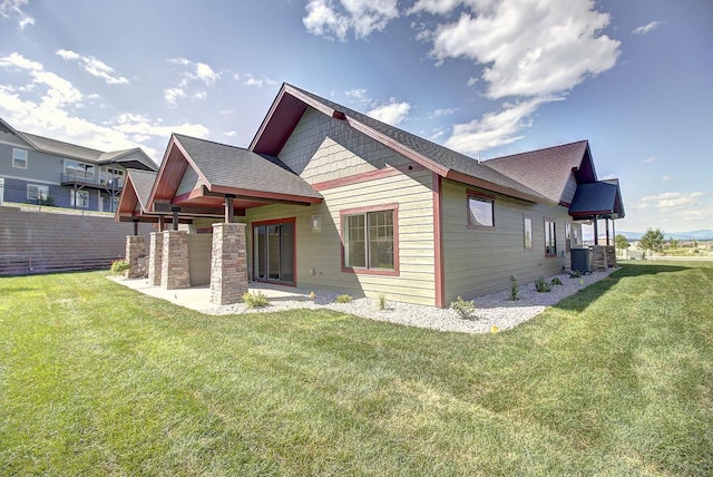 178 Meadow Vista Loop Unit A, Kalispell, MT 59901 - rear view of house with a yard, central air condition unit, and roof with shingles