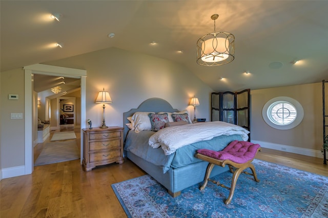 33702 N Finley Point Rd, Polson, MT 59860 - bedroom with lofted ceiling, wood finished floors, a chandelier, and baseboards