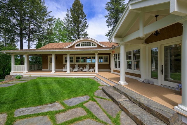 33702 N Finley Point Rd, Polson, MT 59860 - rear view of property featuring a shingled roof, a yard, and a porch