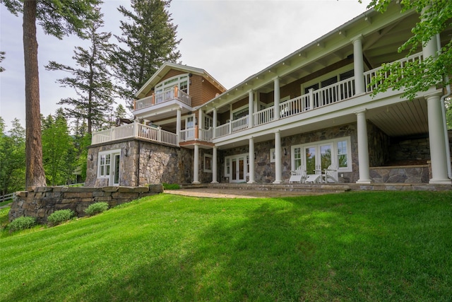 33702 N Finley Point Rd, Polson, MT 59860 - back of property with french doors, stone siding, a lawn, and a balcony