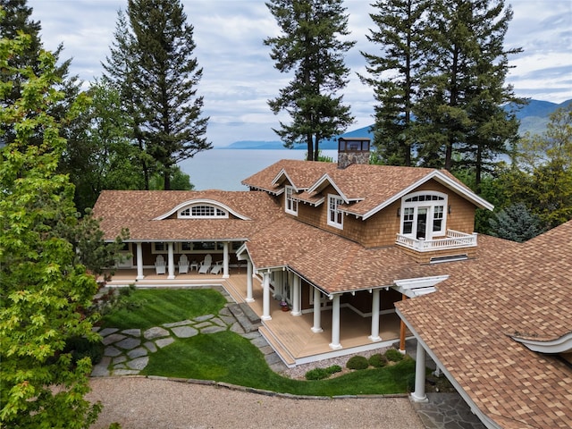 33702 N Finley Point Rd, Polson, MT 59860 - view of front of property featuring a porch, roof with shingles, and a chimney