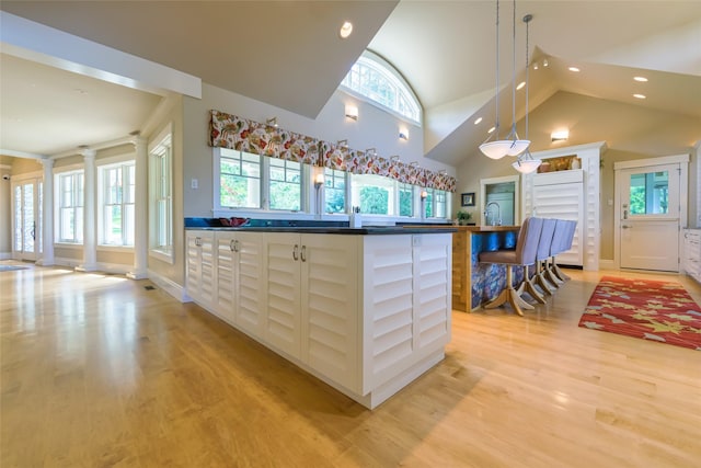 33702 N Finley Point Rd, Polson, MT 59860 - kitchen with ornate columns, recessed lighting, light wood-style floors, dark countertops, and baseboards
