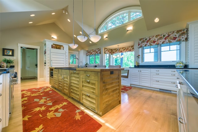 33702 N Finley Point Rd, Polson, MT 59860 - kitchen with light wood-style flooring, recessed lighting, a kitchen island with sink, healthy amount of natural light, and high vaulted ceiling