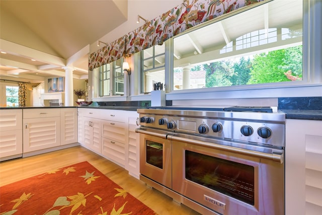 33702 N Finley Point Rd, Polson, MT 59860 - kitchen with range with two ovens, lofted ceiling, light wood-style floors, dark countertops, and ornate columns