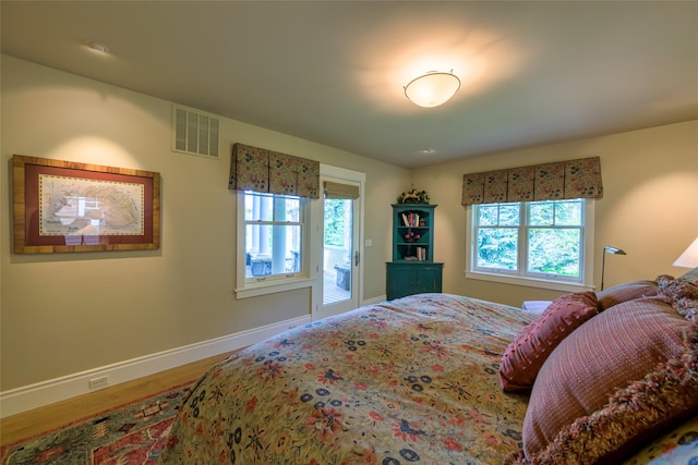 33702 N Finley Point Rd, Polson, MT 59860 - bedroom featuring multiple windows, baseboards, and wood finished floors