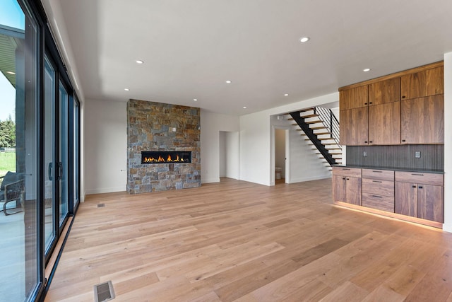 165 River Ranch Rd, Whitefish, MT 59937 - unfurnished living room featuring stairs, light wood finished floors, recessed lighting, a fireplace, and baseboards