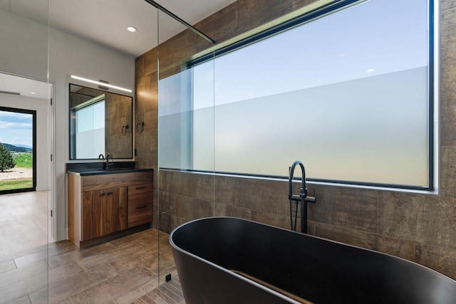 165 River Ranch Rd, Whitefish, MT 59937 - bathroom featuring tile walls, a soaking tub, and vanity