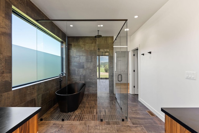 165 River Ranch Rd, Whitefish, MT 59937 - bathroom with a freestanding bath, a stall shower, vanity, tile walls, and recessed lighting