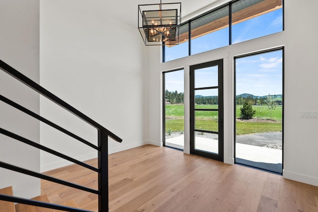 165 River Ranch Rd, Whitefish, MT 59937 - doorway with baseboards, a chandelier, hardwood / wood-style floors, a high ceiling, and a mountain view