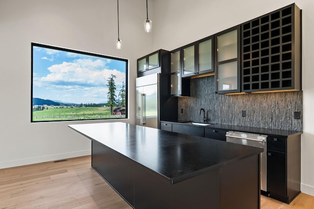 165 River Ranch Rd, Whitefish, MT 59937 - kitchen featuring stainless steel appliances, dark countertops, tasteful backsplash, light wood-type flooring, and decorative light fixtures
