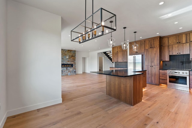165 River Ranch Rd, Whitefish, MT 59937 - kitchen with appliances with stainless steel finishes, dark countertops, brown cabinetry, recessed lighting, and light wood-type flooring