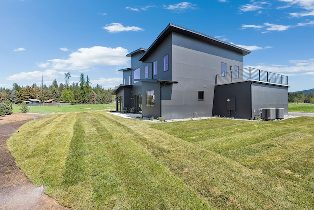 165 River Ranch Rd, Whitefish, MT 59937 - rear view of property with central air condition unit, a balcony, and a lawn