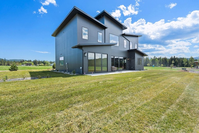 165 River Ranch Rd, Whitefish, MT 59937 - rear view of house featuring a yard, a patio area, and stucco siding