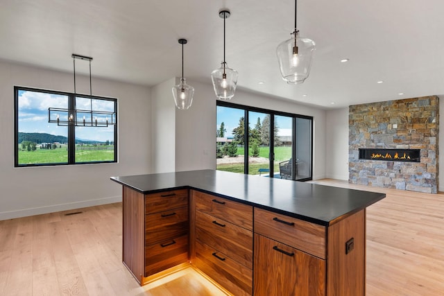 165 River Ranch Rd, Whitefish, MT 59937 - kitchen featuring dark countertops, brown cabinetry, light wood-style flooring, open floor plan, and recessed lighting
