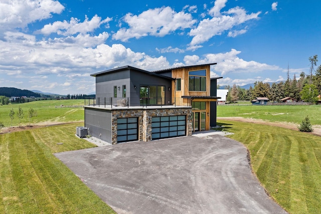 165 River Ranch Rd, Whitefish, MT 59937 - contemporary house with stone siding, central AC, a garage, a mountain view, and a front yard