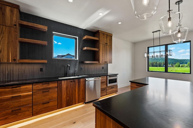 165 River Ranch Rd, Whitefish, MT 59937 - kitchen featuring stainless steel appliances, open shelves, a sink, light wood-style flooring, and decorative backsplash