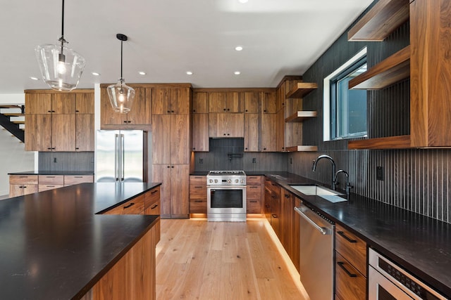 165 River Ranch Rd, Whitefish, MT 59937 - kitchen featuring stainless steel appliances, open shelves, a sink, dark countertops, and brown cabinetry