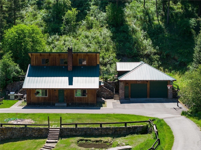 2705 Lyon Creek Rd, Missoula, MT 59804 - view of front of home featuring stairs, a front yard, metal roof, and a garage