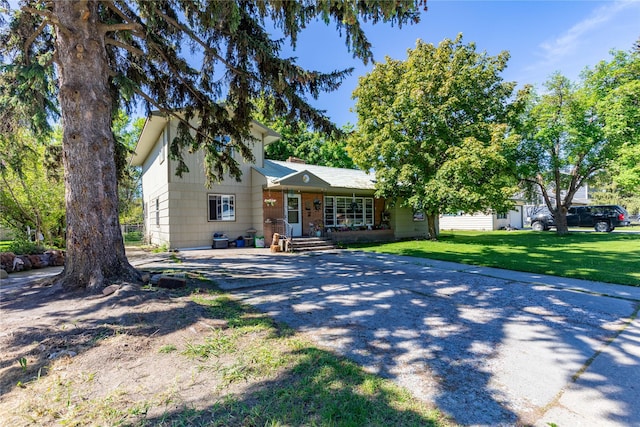1319 3rd St, Whitefish, MT 59937 - view of front of property with covered porch, driveway, and a front lawn
