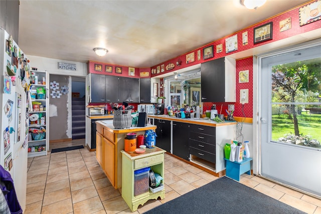 1319 3rd St, Whitefish, MT 59937 - kitchen with healthy amount of natural light, light tile patterned flooring, light countertops, and dark cabinetry