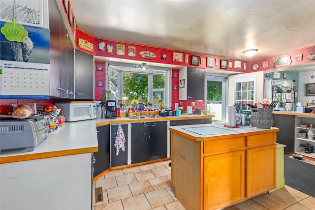 1319 3rd St, Whitefish, MT 59937 - kitchen featuring white microwave, light countertops, cooktop, and light tile patterned floors