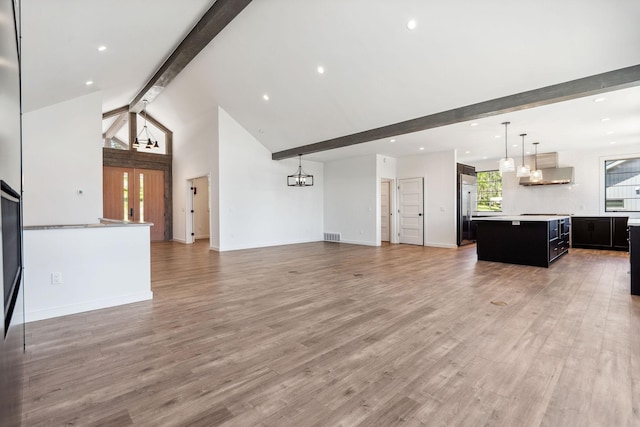 148 Blacktail Loop, Lakeside, MT 59922 - unfurnished living room featuring beamed ceiling, light wood finished floors, high vaulted ceiling, baseboards, and recessed lighting