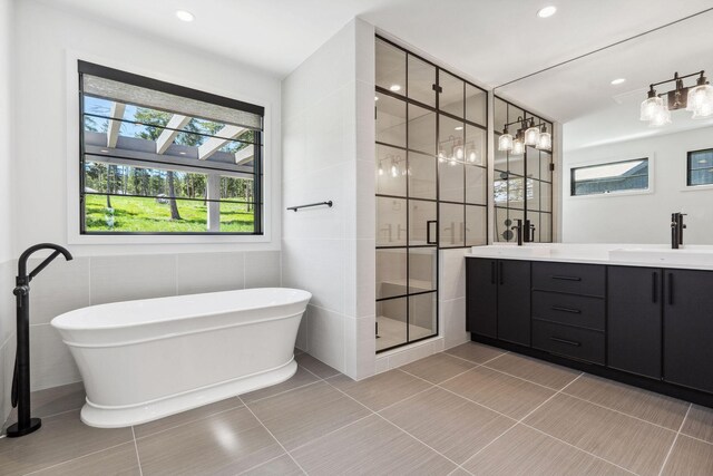 148 Blacktail Loop, Lakeside, MT 59922 - bathroom with double vanity, a stall shower, a soaking tub, tile patterned floors, and tile walls