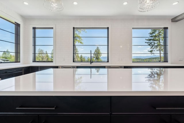148 Blacktail Loop, Lakeside, MT 59922 - kitchen view of dark cabinets, light countertops, a sink, recessed lighting, and a chandelier
