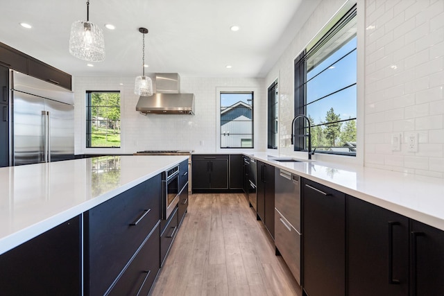 148 Blacktail Loop, Lakeside, MT 59922 - kitchen with appliances with stainless steel finishes, a sink, wall chimney range hood, modern cabinets, and light countertops