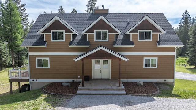 115 Wagon Wheel Rd, Whitefish, MT 59937 - view of front facade with a chimney, a shingled roof, and a deck