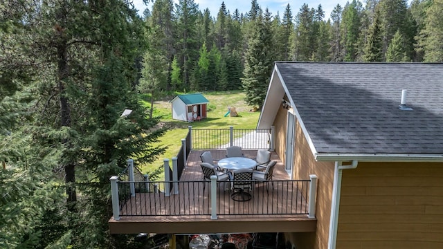 115 Wagon Wheel Rd, Whitefish, MT 59937 - wooden terrace featuring outdoor dining space, a forest view, a storage shed, and a yard