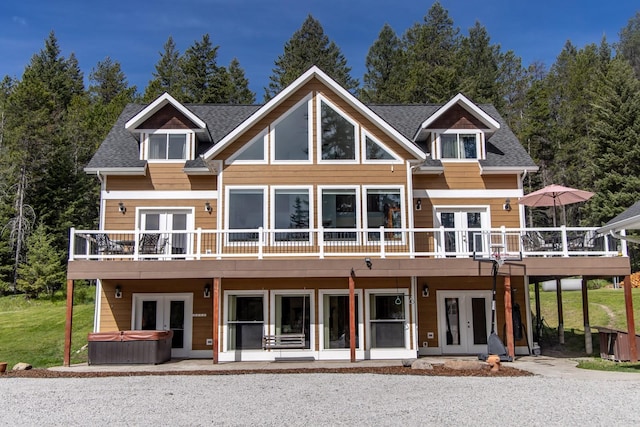115 Wagon Wheel Rd, Whitefish, MT 59937 - rear view of house featuring french doors, a hot tub, a deck, roof with shingles, and a patio