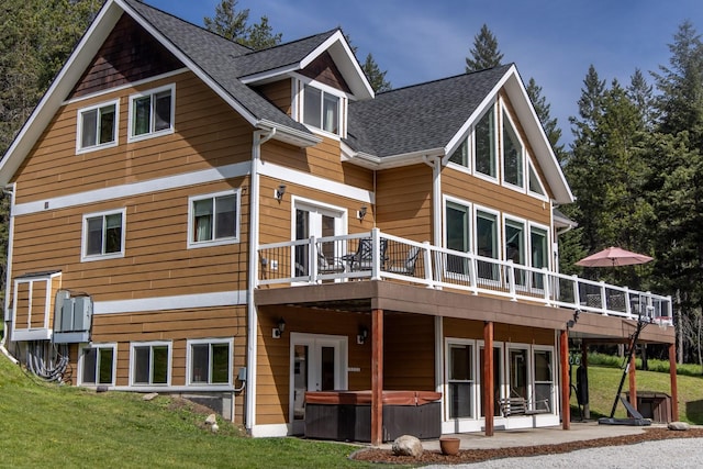 115 Wagon Wheel Rd, Whitefish, MT 59937 - back of property featuring a hot tub, a deck, and a lawn