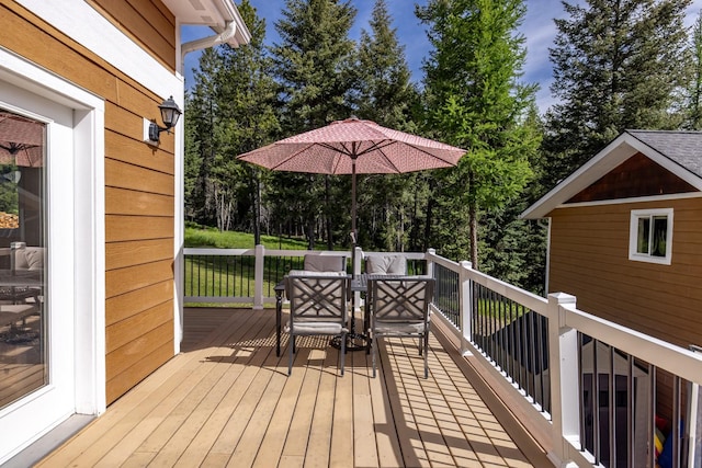 115 Wagon Wheel Rd, Whitefish, MT 59937 - wooden deck with view of wooded area and outdoor dining area