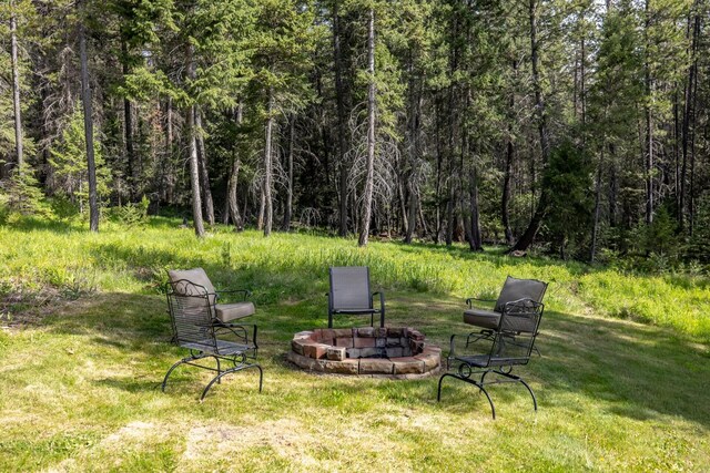 115 Wagon Wheel Rd, Whitefish, MT 59937 - view of grassy yard featuring a fire pit and a view of trees