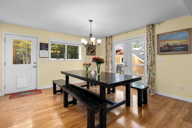 115 Wagon Wheel Rd, Whitefish, MT 59937 - dining room with french doors, healthy amount of natural light, light wood-type flooring, and a chandelier