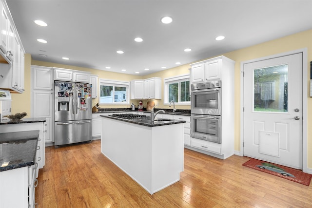 115 Wagon Wheel Rd, Whitefish, MT 59937 - kitchen with stainless steel appliances, white cabinetry, light wood-style floors, dark stone counters, and recessed lighting