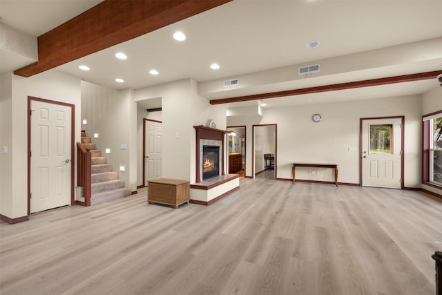 115 Wagon Wheel Rd, Whitefish, MT 59937 - unfurnished living room with recessed lighting, light wood-type flooring, beam ceiling, stairs, and a glass covered fireplace