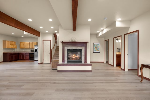 115 Wagon Wheel Rd, Whitefish, MT 59937 - unfurnished living room with beam ceiling, recessed lighting, light wood-style flooring, a premium fireplace, and stairway