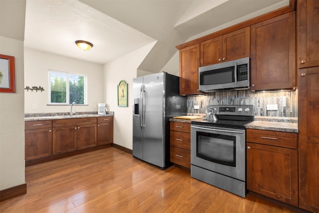 115 Wagon Wheel Rd, Whitefish, MT 59937 - kitchen featuring appliances with stainless steel finishes, tasteful backsplash, light wood finished floors, and brown cabinets