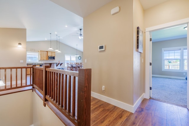 7567 Kingpost Loop, Helena, MT 59602 - hallway featuring wood-type flooring, baseboards, vaulted ceiling, and an upstairs landing