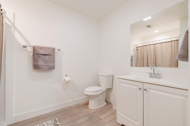 7567 Kingpost Loop, Helena, MT 59602 - full bathroom featuring toilet, vanity, wood finished floors, baseboards, and curtained shower