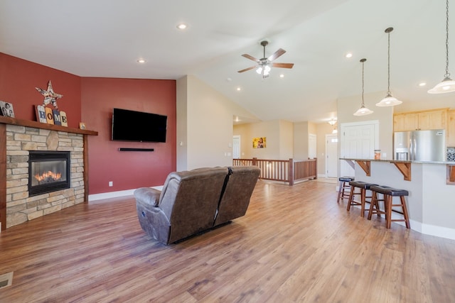 7567 Kingpost Loop, Helena, MT 59602 - living area featuring light wood-style floors, ceiling fan, lofted ceiling, a fireplace, and baseboards