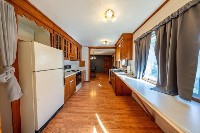 411 Colorado Ave, Libby, MT 59923 - kitchen with freestanding refrigerator, electric range oven, brown cabinetry, a chandelier, and glass insert cabinets