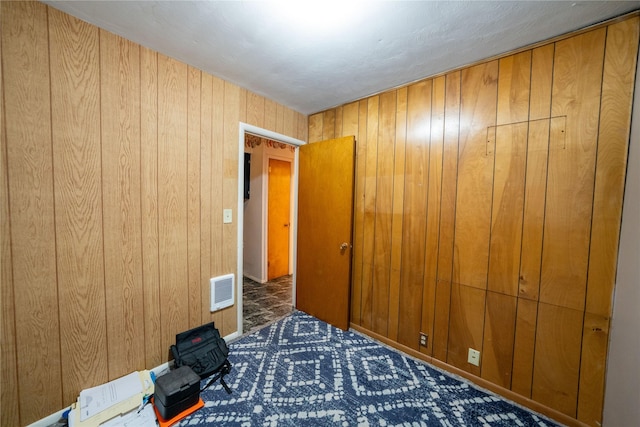 411 Colorado Ave, Libby, MT 59923 - unfurnished bedroom with wood walls and carpet flooring