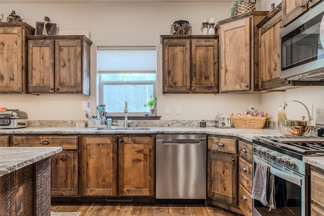 224 Forest Edge Trl, Kalispell, MT 59901 - kitchen featuring appliances with stainless steel finishes, dark wood-style flooring, and light stone countertops