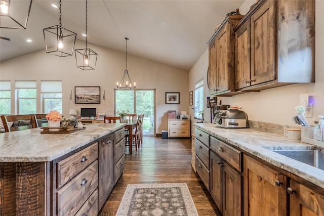 224 Forest Edge Trl, Kalispell, MT 59901 - kitchen featuring hanging light fixtures, healthy amount of natural light, dark wood-style floors, high vaulted ceiling, and a kitchen island