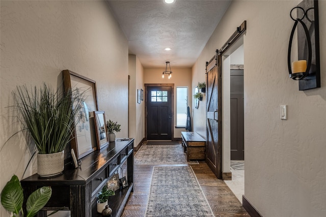 224 Forest Edge Trl, Kalispell, MT 59901 - foyer featuring a textured wall, a textured ceiling, dark wood-style floors, a barn door, and baseboards