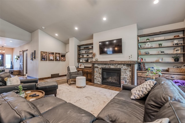 224 Forest Edge Trl, Kalispell, MT 59901 - living area featuring wood finished floors, lofted ceiling, recessed lighting, a stone fireplace, and baseboards